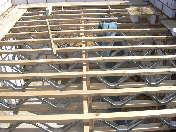 Vakwerkliggers uit hout gecombineerd met metaal als vloerconstructie.